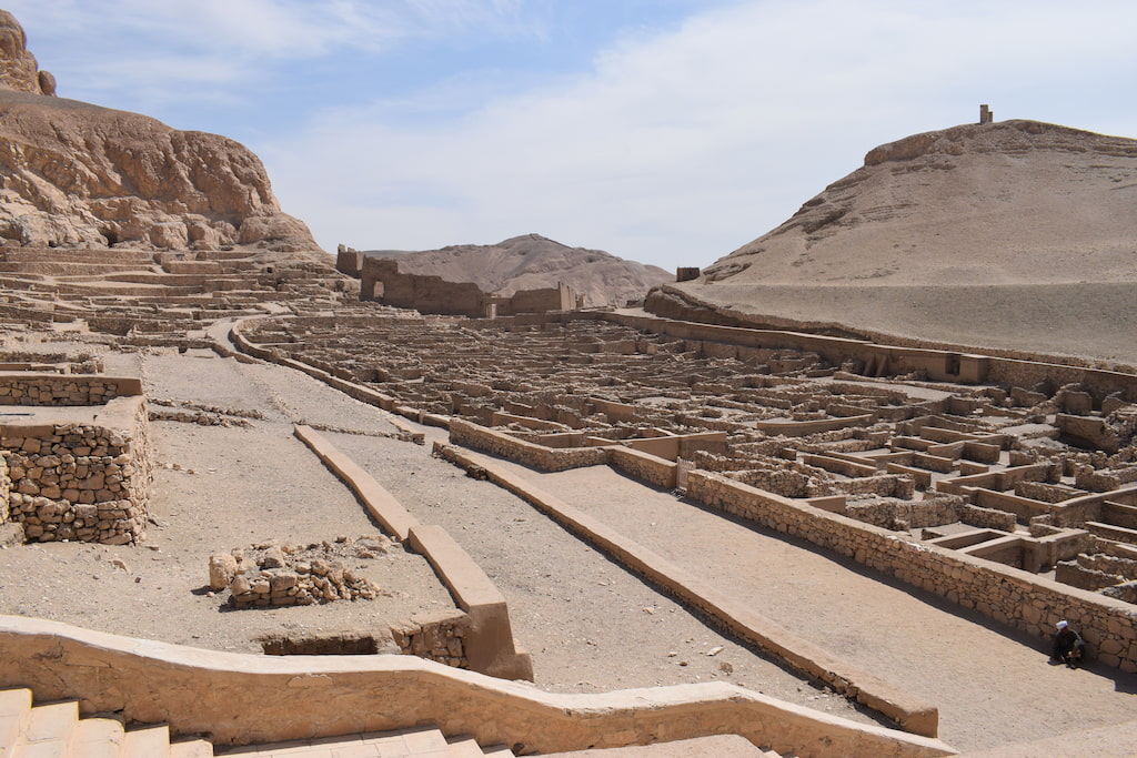 Aerial view of the ancient Deir el-Medina excursion site showing workers' village ruins with limestone cliffs in the background on Luxor's West Bank, Egypt