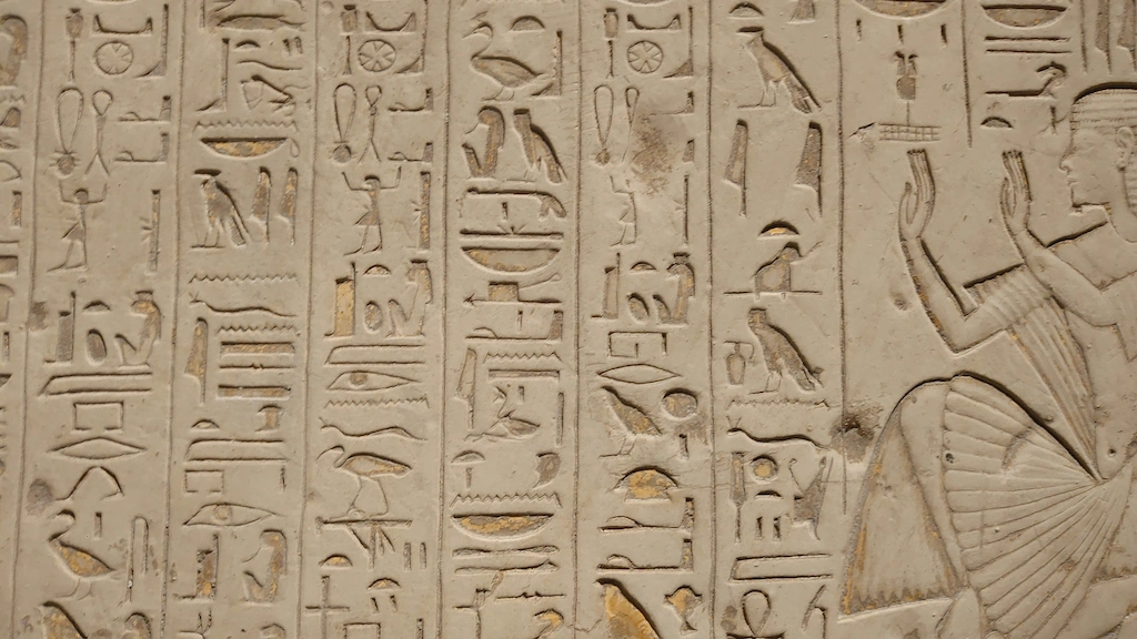Ancient Egyptian hieroglyphics carved on a tomb wall — the type of inscriptions mistaken for the curse of the pharaohs - king tut tour curse