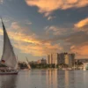 Traditional felucca sailboat at sunset near a Nile cruise ship in Aswan