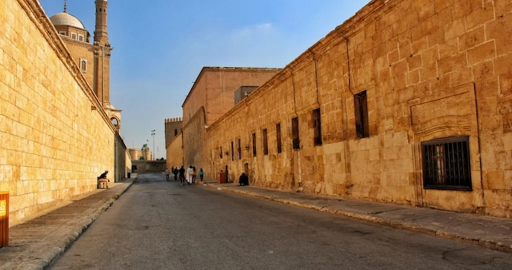 Medieval alleys of Islamic Cairo lined with ancient stone walls near a mosque