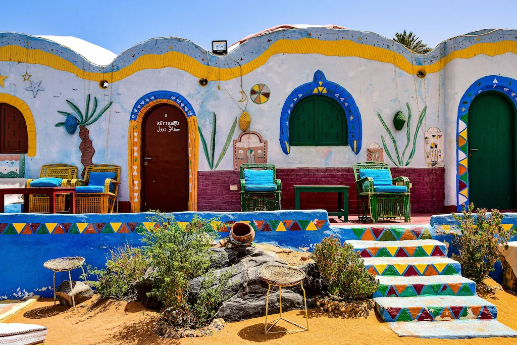 Upper Egypt Travel Guide - Brightly painted courtyard walls typical of a traditional Nubian village near Aswan