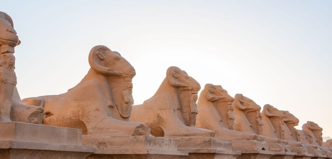Ram-headed sphinx avenue at Karnak, ancient capital of Egypt at sunset