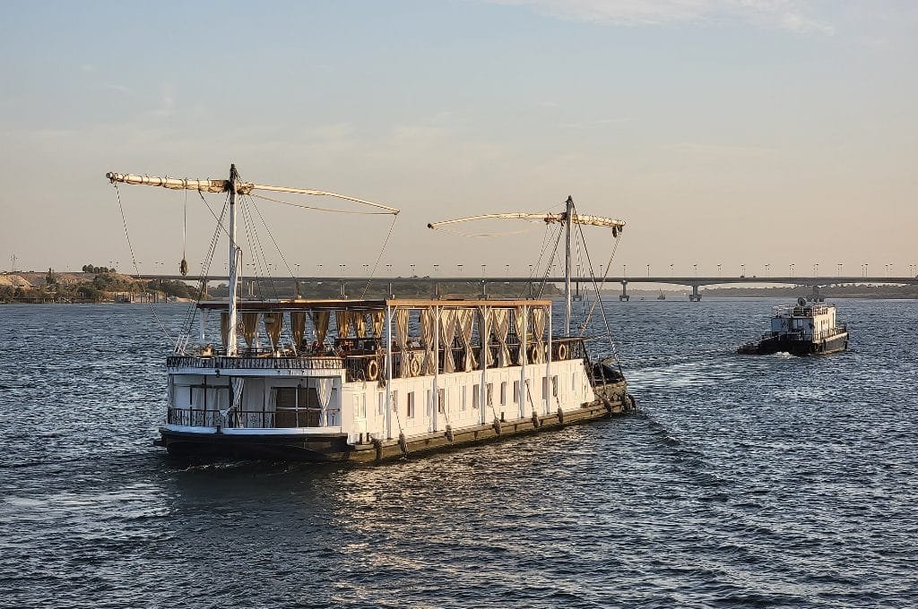 Dahabiyah vs Nile cruise pace - a dahabiya gently towed along a quiet stretch of the Nile