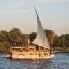 Dahabiya ou croisière sur le Nil : dahabiya traditionnelle toutes voiles dehors sur le Nil à l’heure dorée