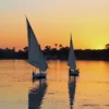 Christmas in Egypt: felucca sails on the Nile at golden sunset, a calm winter evening in Upper Egypt