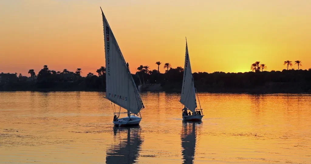 Christmas in Egypt: felucca sails on the Nile at golden sunset, a calm winter evening in Upper Egypt