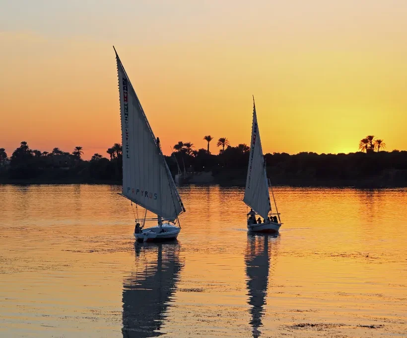 Christmas in Egypt: felucca sails on the Nile at golden sunset, a calm winter evening in Upper Egypt