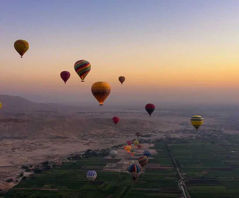 Christmas vacation ideas: hot air balloons rising over Luxor at sunrise