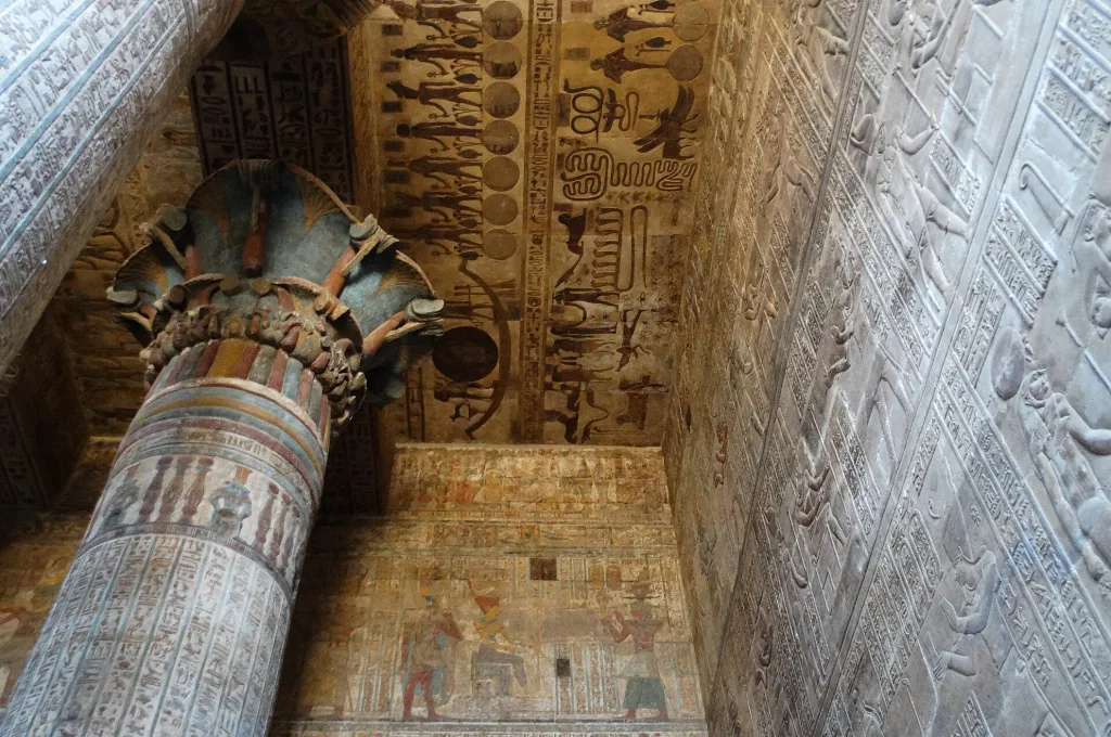 Esna Tempel Ägypten: bemalte Säule mit farbigem Kapitell unter der beschrifteten Decke