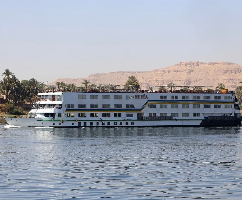 Heiligabend auf einer Nilkreuzfahrt: ein weißes Kreuzfahrtschiff fährt bei Luxor auf dem Nil