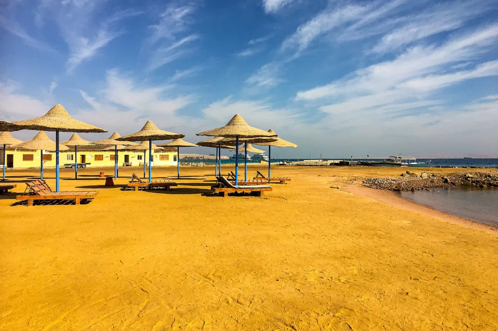 Strandschirme am Ufer des Roten Meeres bei Hurghada bei Sonnenuntergang