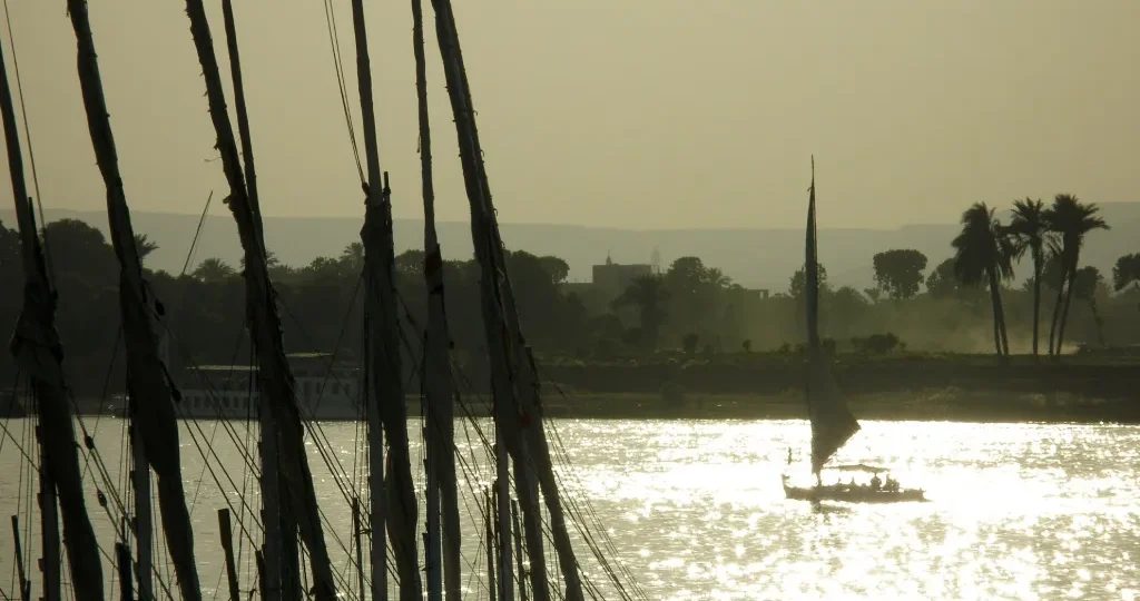Sailboat masts on the Nile at dusk near Luxor