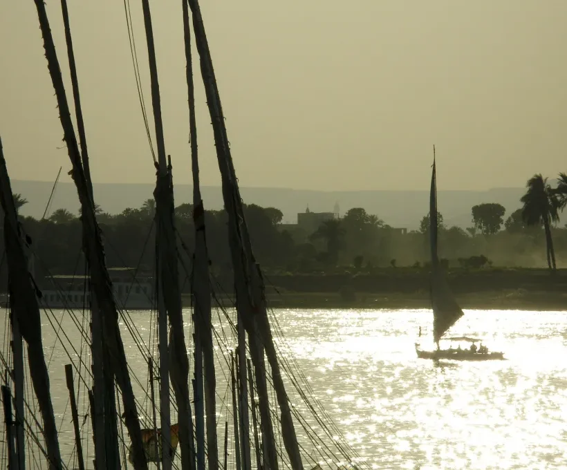 Sailboat masts on the Nile at dusk near Luxor