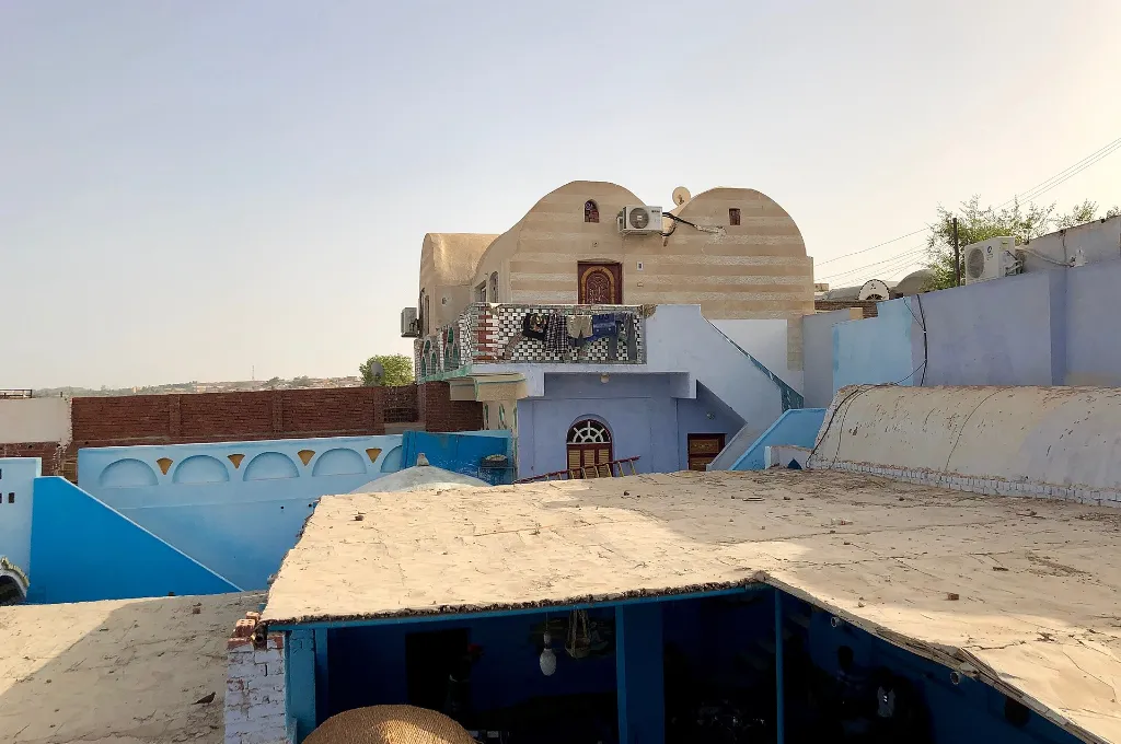 Blue-painted Nubian house under a clear sky near Aswan, a sunny stop on warm Christmas vacations