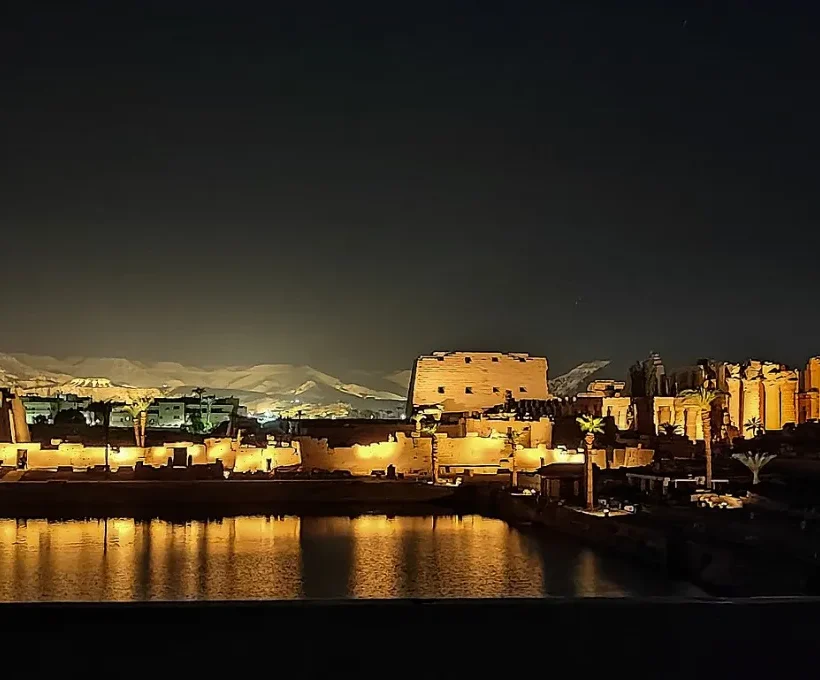 Weihnachten und Silvester in Ägypten: ein beleuchteter Tempel am Nil spiegelt sich bei einer abendlichen Ton-und-Licht-Show im Wasser